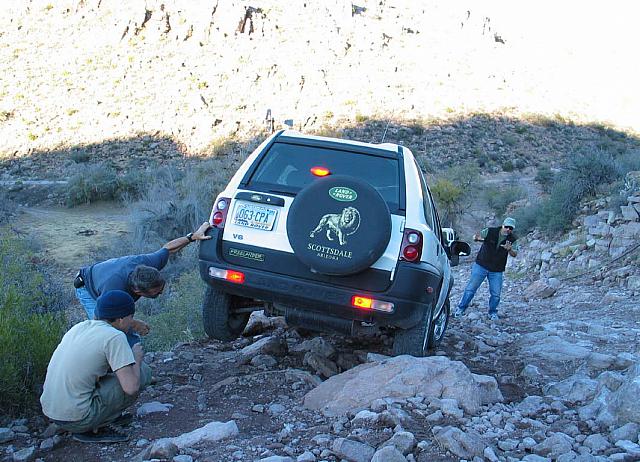 It's Mike's turn to lift the Freelander.  He and Brandon admire all the broken pieces underneath as Leo prepares to paint a port