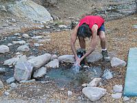 Carl rinses his hands in the spring.